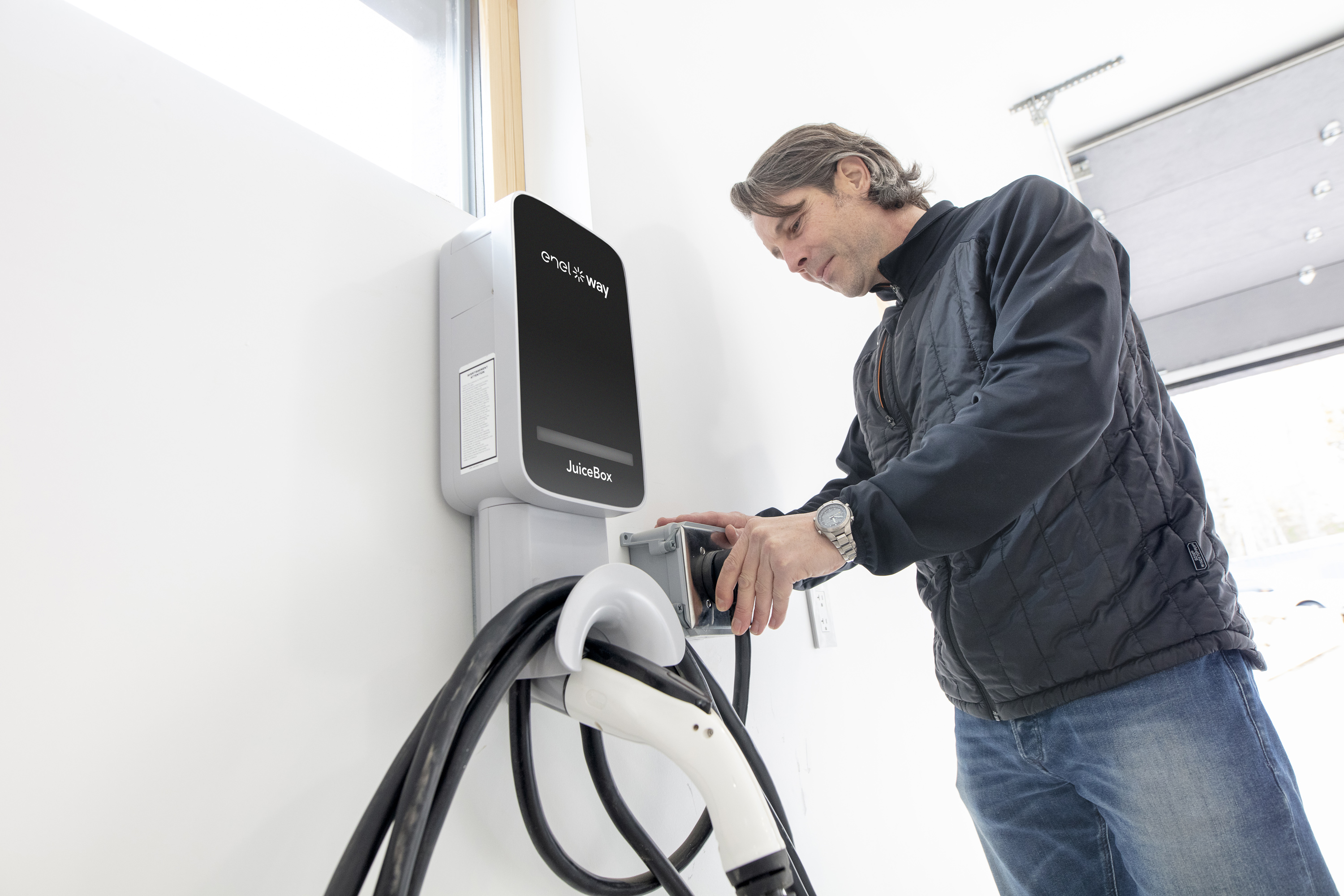 Man setting up his charging port in his garage